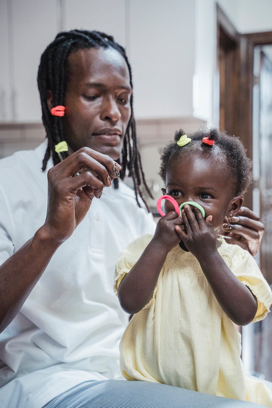 man putting hair accessories on a baby girl s hair